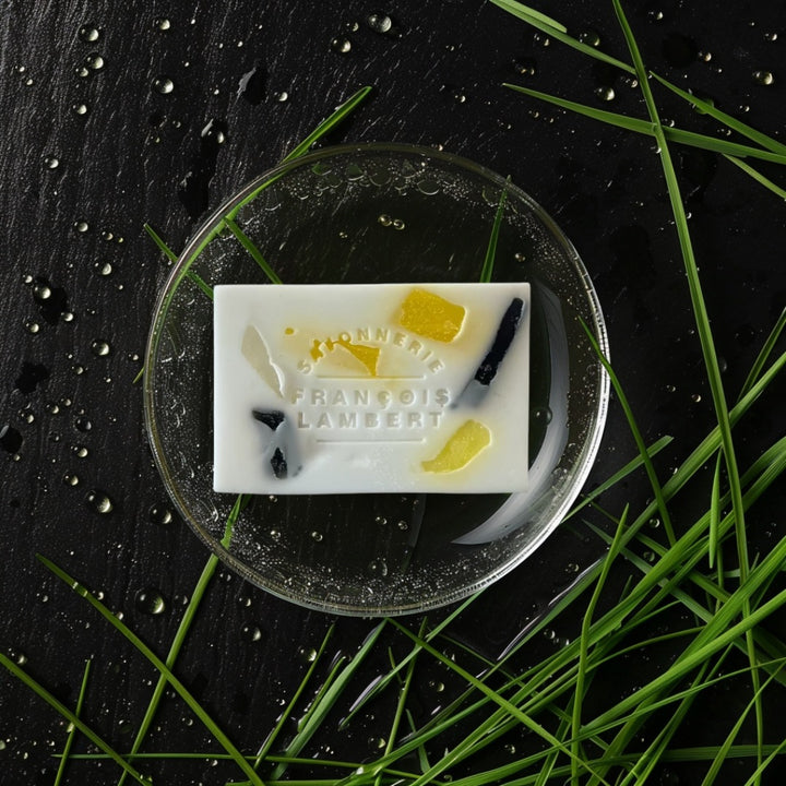 savon à la fragrance pluie de terre sur un fond noir avec des gouttes de pluie et de l&